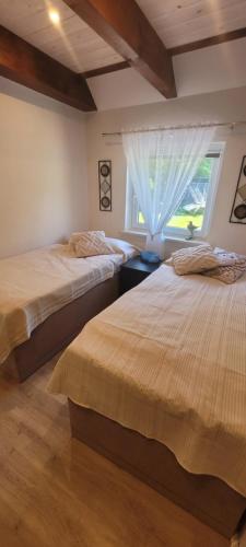 two beds in a room with a window at Ferienhaus Landidyll in Fehmarn