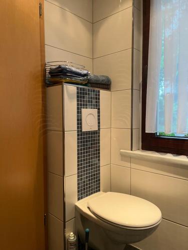 a small bathroom with a toilet and a window at First Tee am Rosarium in Sangerhausen