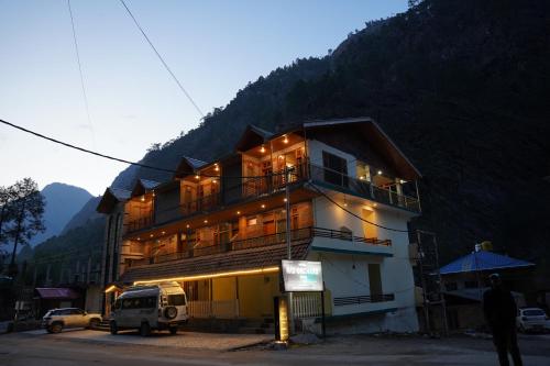 a building with a van parked in front of it at Hotel Mid Orchard Kasol -River Side in Kasol