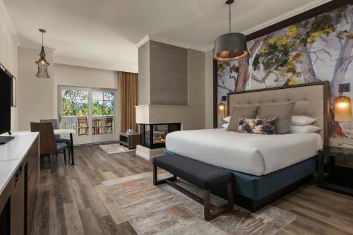 a bedroom with a large bed and a fireplace at River Terrace Inn in Napa
