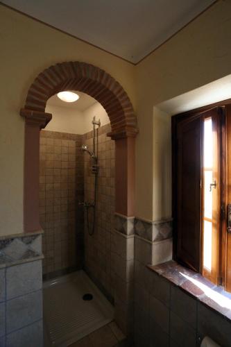 a bathroom with a shower with an arch in it at Molino del Rotone in Buti