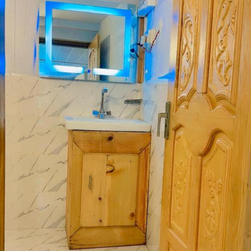 a bathroom with a sink and a mirror and a door at The Royal Peaks in Kundālshai