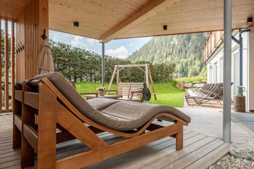 a hammock on a porch with a swing at Naturhotel Falknerhof in Niederthai