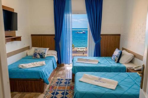 a room with two beds with a view of the ocean at Acropole Alexandria Hotel in Alexandria