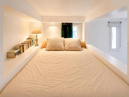 a large bed in a white room with a window at " Studio Vasconia " Hyper Centre - Mezzanine -Wifi in Muret