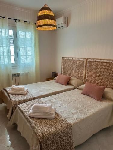 a bedroom with two beds with towels on them at Villa Vistamar - Piscina privada, vistas al mar y a 5 min de la playa in Cala en Porter