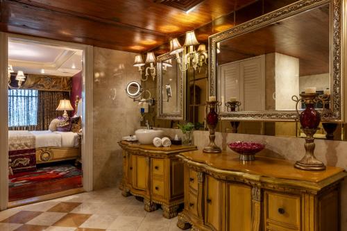 a bathroom with a sink and a mirror and a bed at Tuli Imperial in Nagpur