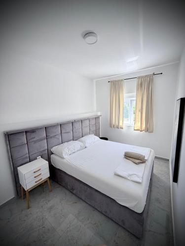a white bedroom with a large bed and a window at Vip Villa Tina in Novalja