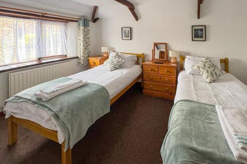 a bedroom with two beds and a dresser at 2 Bed in St. Merryn oc-w29716 in Saint Merryn