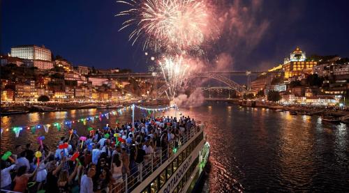 a crowd of people standing on a bridge watching fireworks at Casas São João by Ana Ferro Rentals in Arcozelo