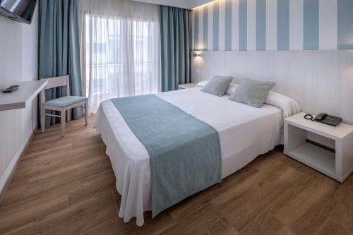 a hotel room with a large bed and a desk at Mercè in Pineda de Mar