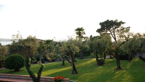 a park with trees and green grass and flowers at Hotel Désirée - Garda Lake Collection in Sirmione