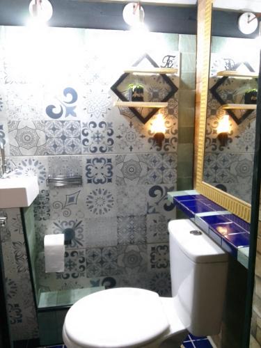 a bathroom with a toilet and a sink and a mirror at Chalé amora Analândia in Analândia