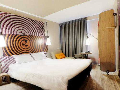 a hotel room with a large white bed and a window at ibis Apartado in Apartadó