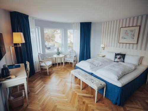 a bedroom with a large bed and a table and chairs at Havgrim Seaside Hotel 1948 in Tórshavn