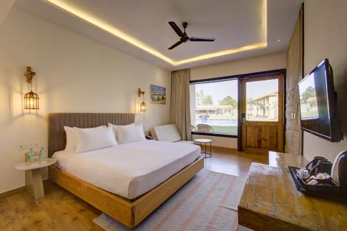 a hotel room with a bed and a television at Cygnett Collection in Jim Corbett