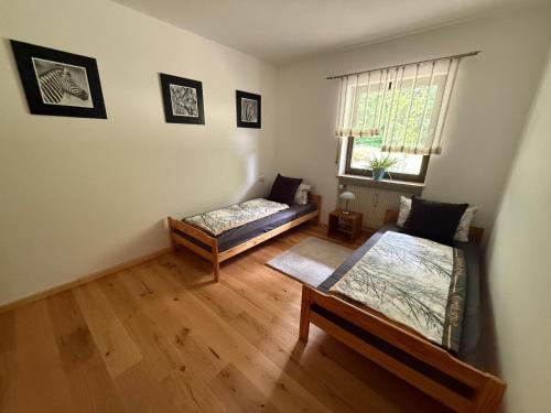 a living room with two beds and a window at Gästeunterkunft Am Hirschbach in Hirschbach