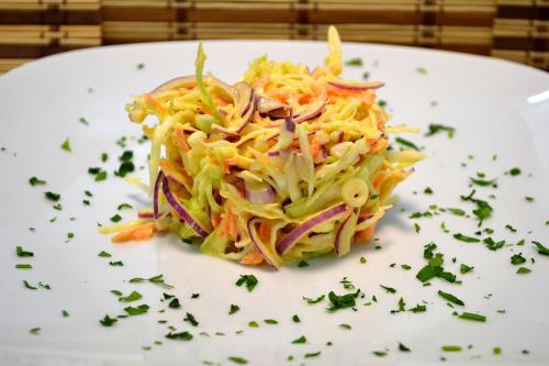 a white plate with a salad with cabbage and carrots at Park House in Dej