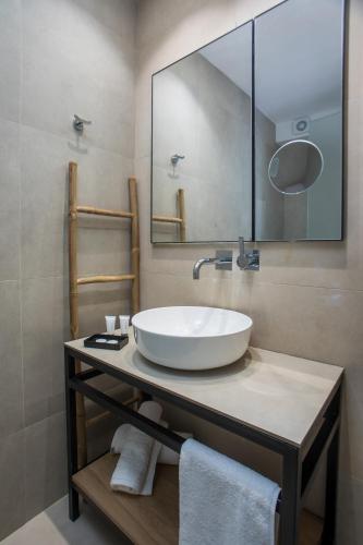 a bathroom with a white sink and a mirror at Pado Living in Faliraki