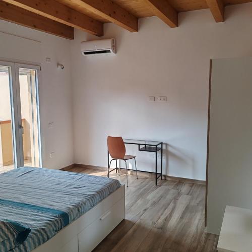 a bedroom with a bed and a desk and a chair at New semi-detached two-room apartment in Monserrato