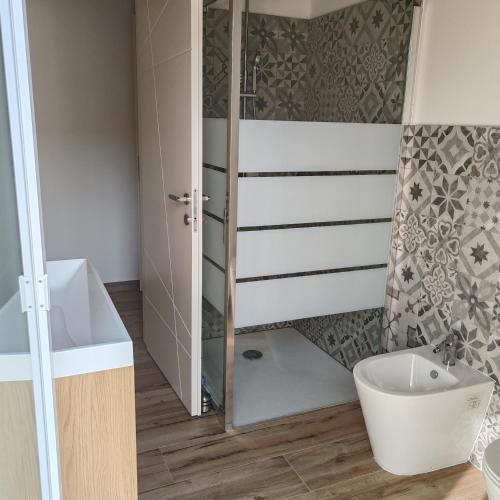 a bathroom with a shower and a toilet and a sink at New semi-detached two-room apartment in Monserrato