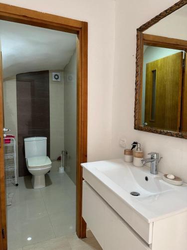 a bathroom with a sink and a toilet and a mirror at Mozona beach 2 in Sidi Rahal