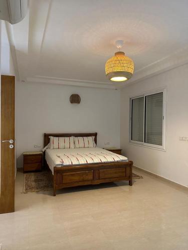 a bedroom with a bed and a chandelier at Mozona beach 2 in Sidi Rahal