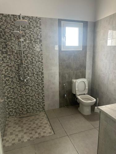 a bathroom with a shower and a toilet at Les jardins de Sara in Mellita