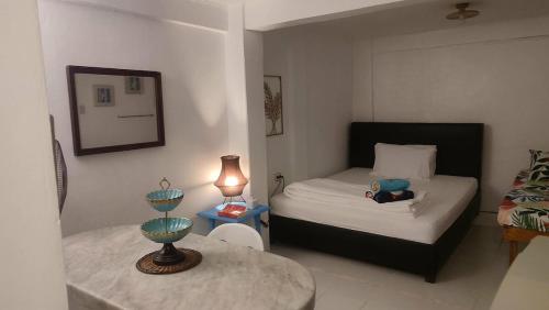 a small bedroom with a bed and a table at Casa Nenen in Romblon