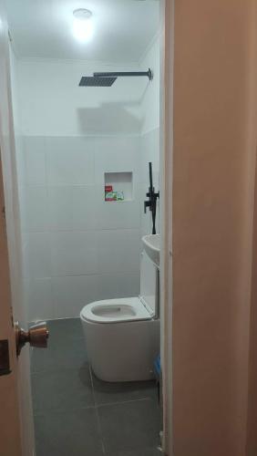 a bathroom with a white toilet and a sink at Casa Nenen in Romblon