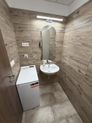 ein Badezimmer mit Waschbecken, Toilette und Spiegel in der Unterkunft Noir Hotel in Szeged