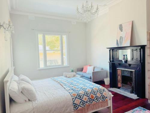 a bedroom with a bed and a fireplace and a chandelier at Perth property - Heritage Charm Meets Modern Ease close to all amenities including Midland Hospital in Midland Junction