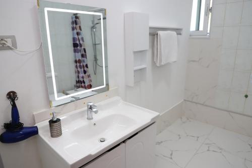 a white bathroom with a sink and a mirror at A&B Berat in Berat