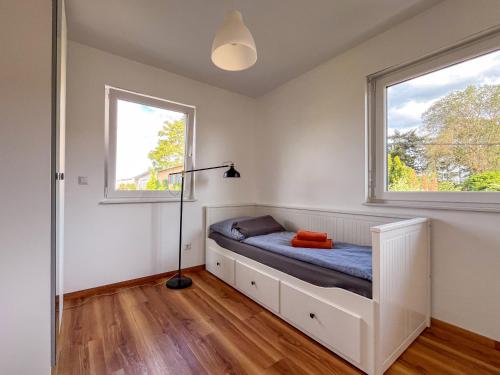 a bedroom with a bed and two windows at Ferienhaus Caputh in Caputh