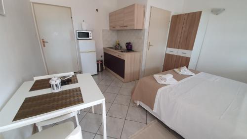 a small room with a bed and a kitchen at Budget Holiday Apartments Primorska in Pag