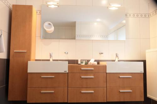 a bathroom with two sinks and brown cabinets at The View in Francorchamps