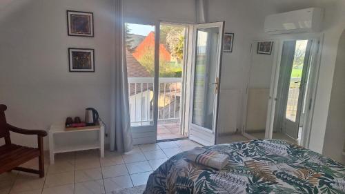 a bedroom with a bed and a sliding glass door at Sur le Chemin d'Arles in Lescar
