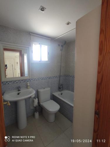 a bathroom with a toilet and a sink and a tub at Apartamento Piles playa in Piles