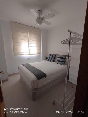 a bedroom with a bed with a ceiling fan at Apartamento Piles playa in Piles