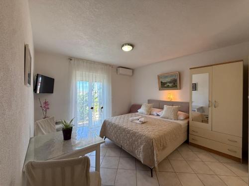 a bedroom with a bed and a desk and a window at Apartments Marina in Sukošan