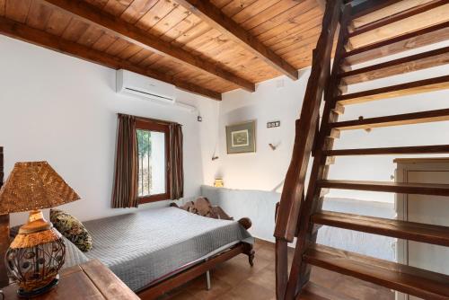a bedroom with a bed and a stair case at Casa Miramar in Almogía