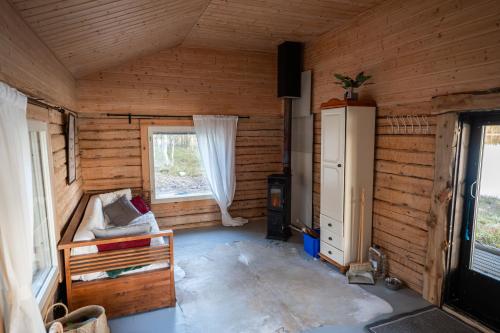 an empty room with a wooden walls and a room with at Kutulammen erämökki saunalla in Ranua