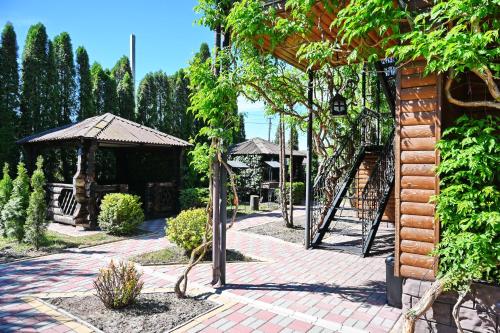 a garden with a brick walkway and a gazebo at Hotel-complex Mizh Triokh Ozer in Svityazʼ