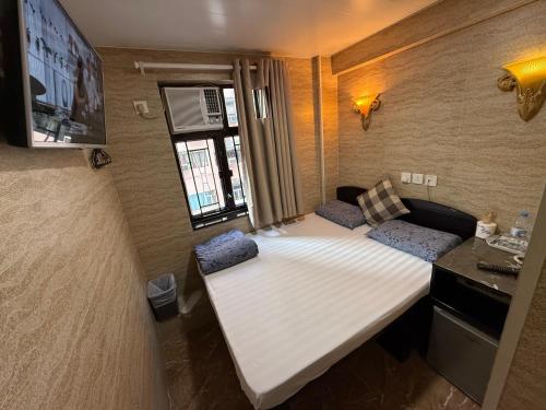 a small room with two beds and a window at Sleep Inn in Hong Kong