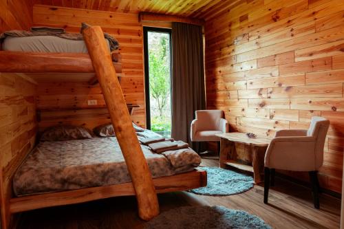 a bedroom with a bunk bed in a log cabin at Wildmont Prokletije in Gusinje