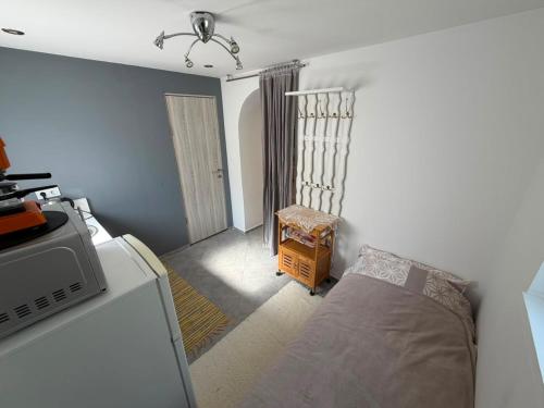 a small bedroom with a bed and a chair at Cozy Studio in Deszk