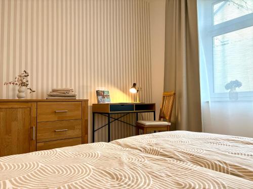 a bedroom with a bed and a dresser and a window at Ferienwohnungen Landeskrone Dresden in Dresden