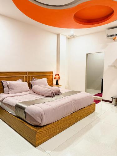 ein Schlafzimmer mit einem großen Bett mit Holzrahmen in der Unterkunft arafah hotel in Sungaipenuh