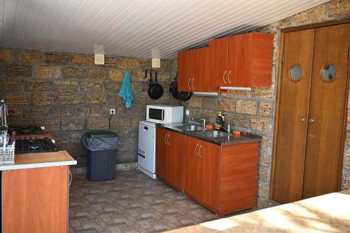 a kitchen with wooden cabinets and a white microwave at Hotel-complex Mizh Triokh Ozer in Svityazʼ