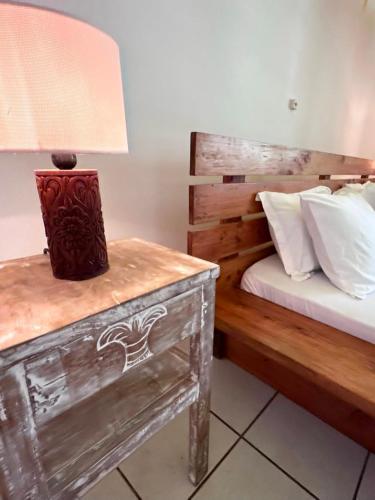 a bedroom with a bed and a table with a lamp at Beach House - private room in Diani Beach